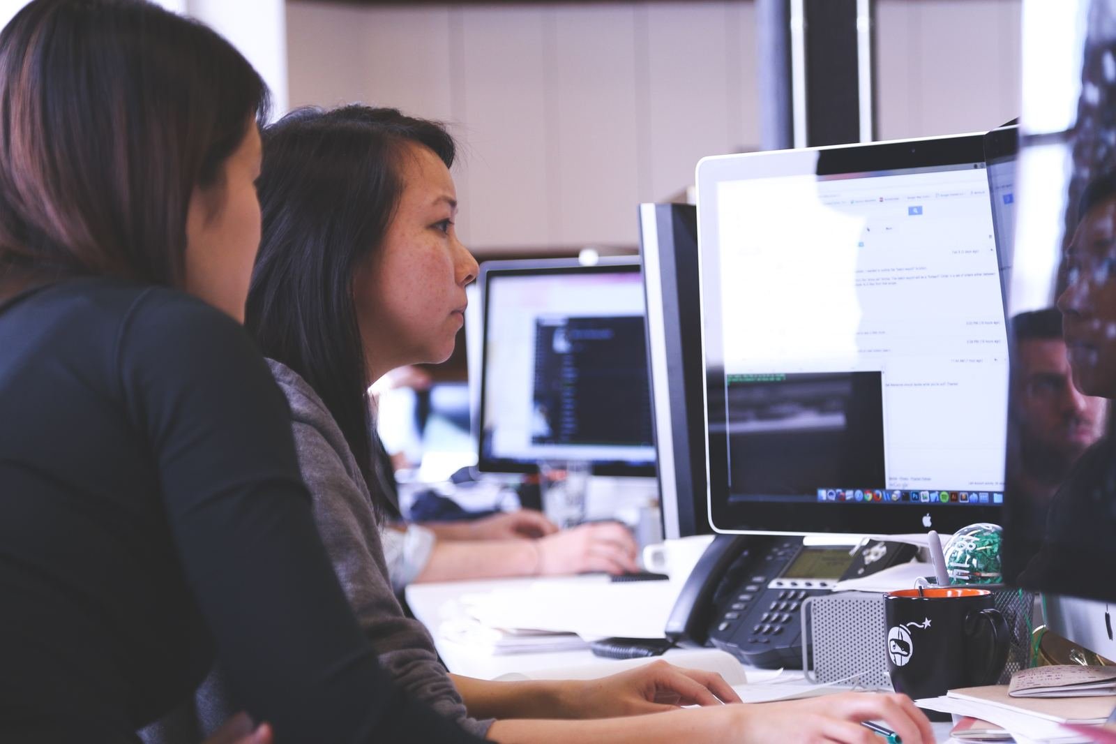 Founders collaborating over financial data on screens